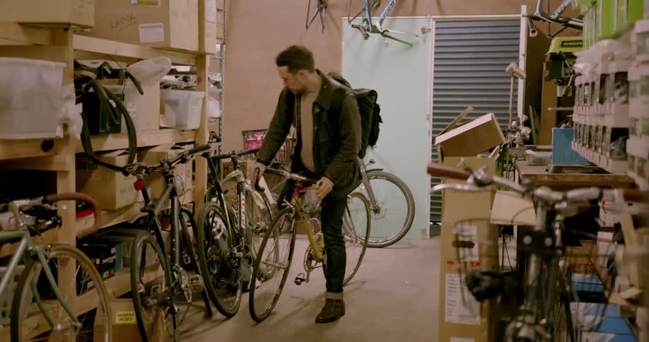 Man walks into bike shop and lays bike against the wall and walks away