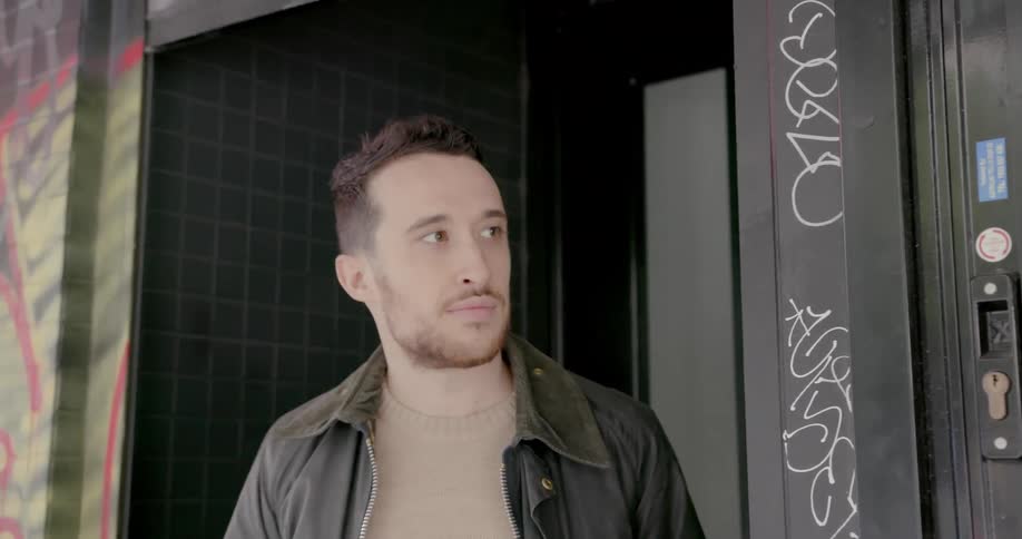 Man lifts door to open store front