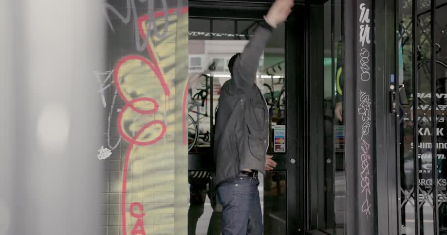 A man opens up a door to the bicycle shop