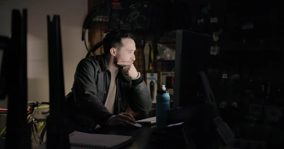 A man looks on a computer in a back room of a shop