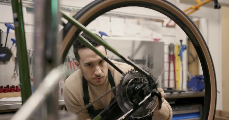 A man fixes a bicycle tire in a workshop