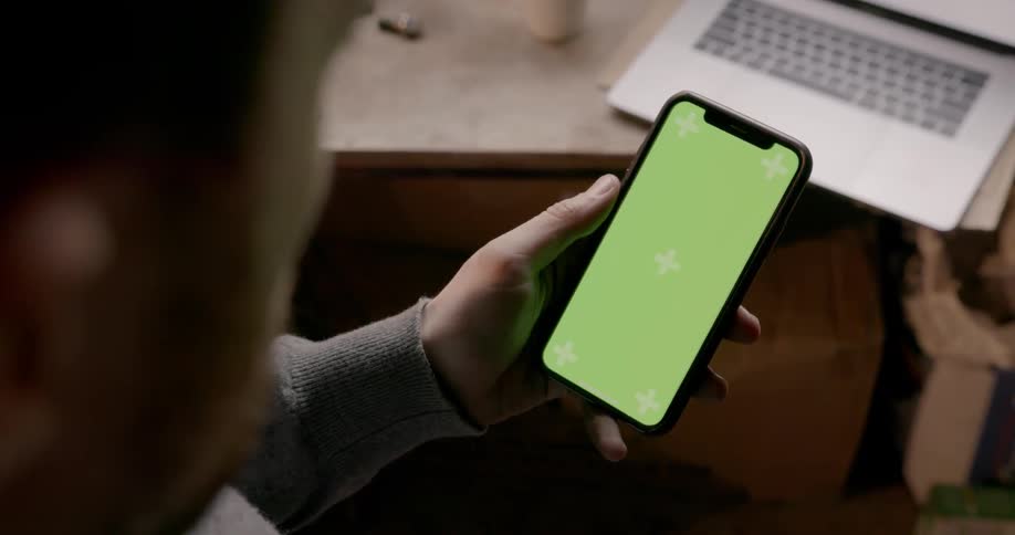 A man is scrolling through his cellphone