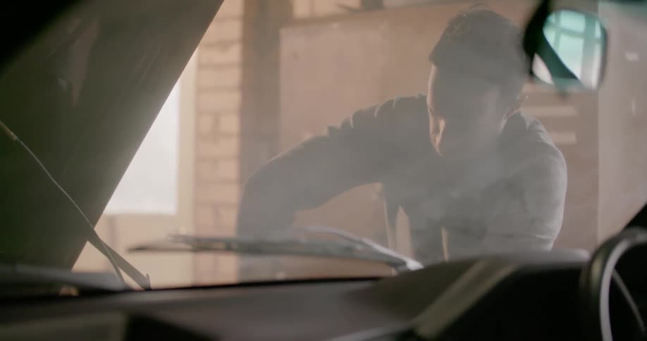 Man works on a car in a garage