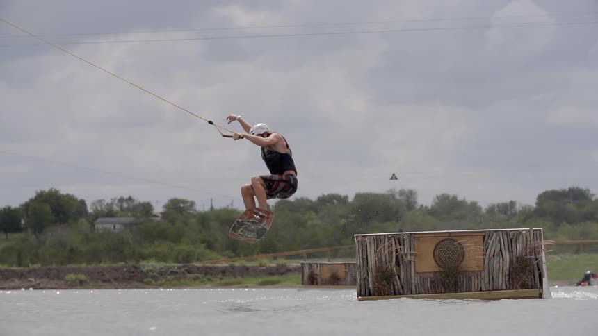 Wakeboarder jumping over a ledge into the water