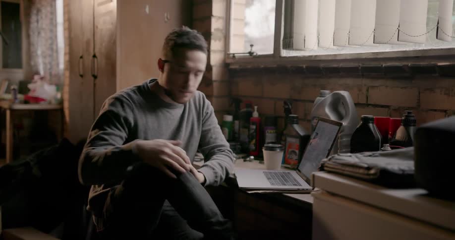 A man works on a laptop at a desk