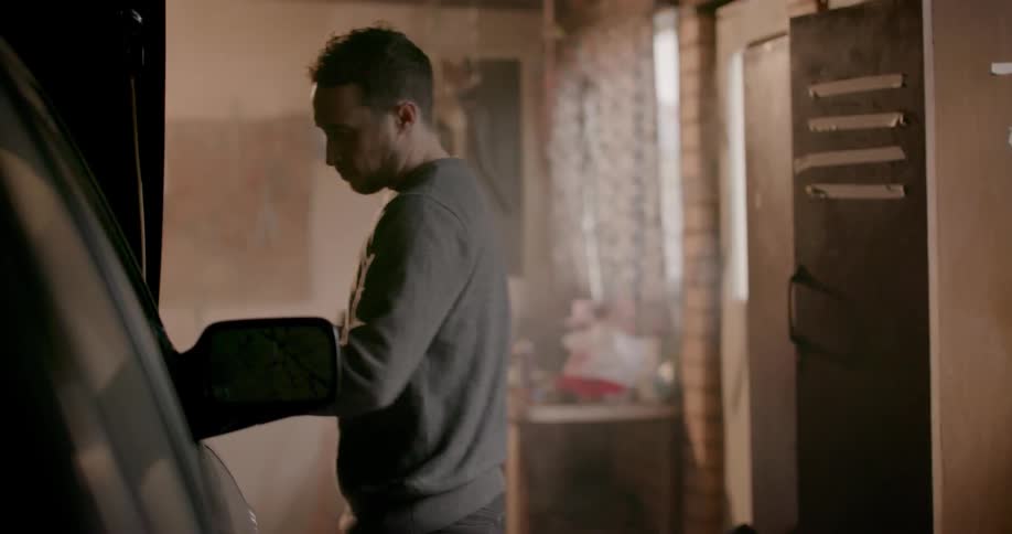 A man fixes a car in a garage