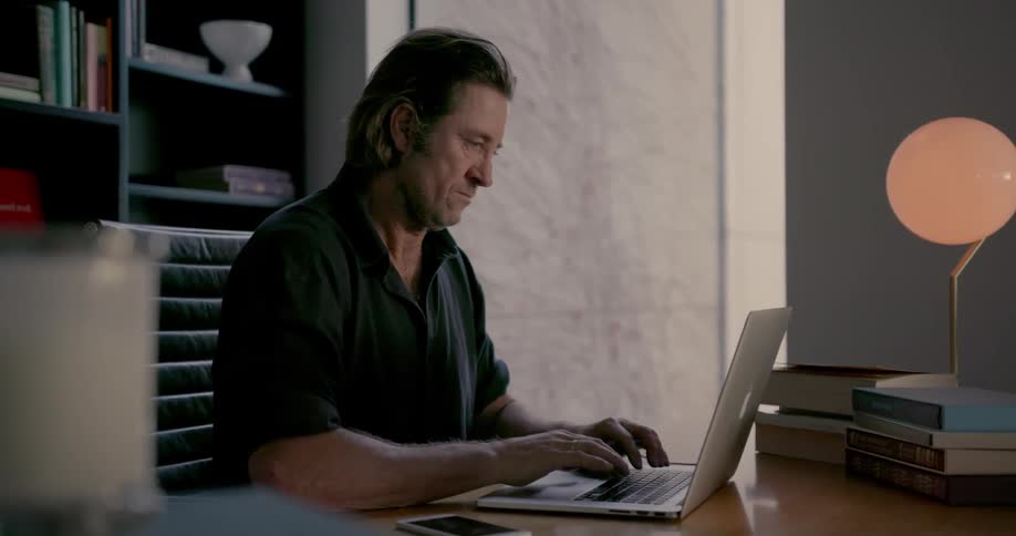 A man is typing on his keyboard at his desk