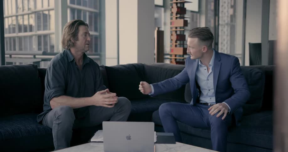 Businessmen have a discussion while sitting in an office during the day