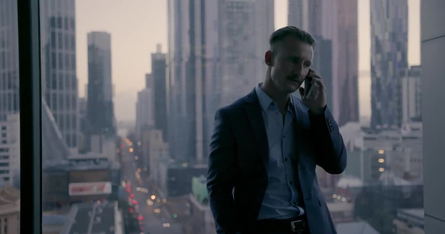 A man is talking on his phone by the window