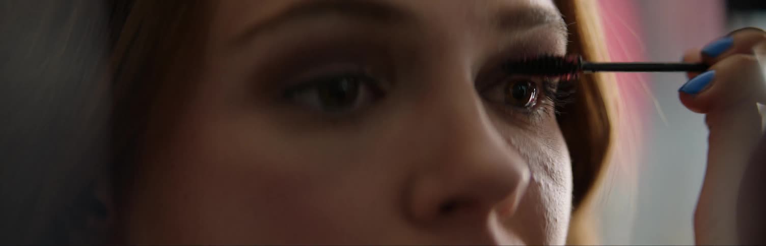 A woman applies mascara