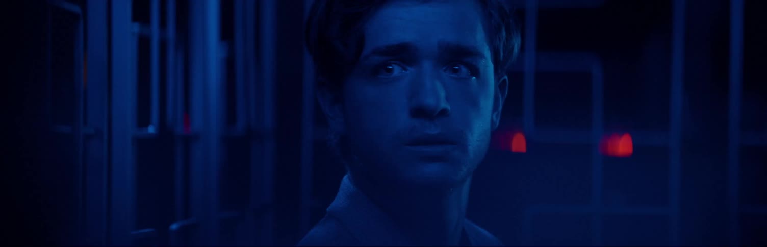 Man in blue room staring off in the distance