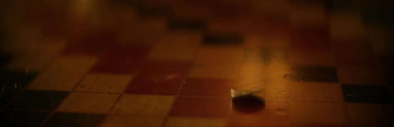 A spinning coin is picked up off a table by a woman