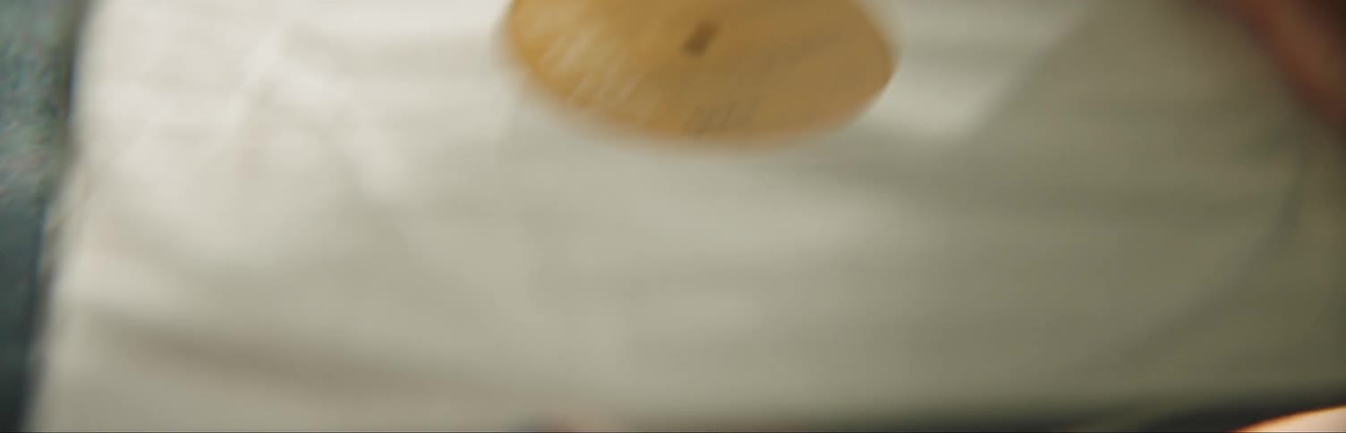 A person lifts up a record and puts it in the case