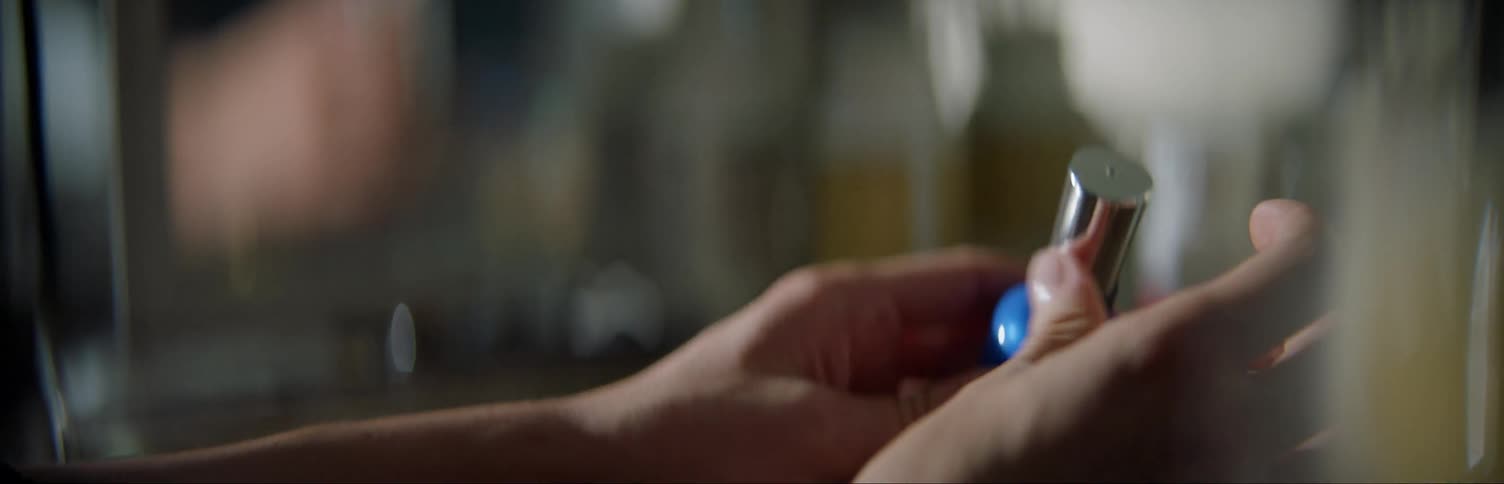 A woman is opening a bottle of nail polish