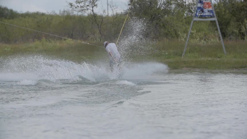 A wakeboarder jumps and flips his board