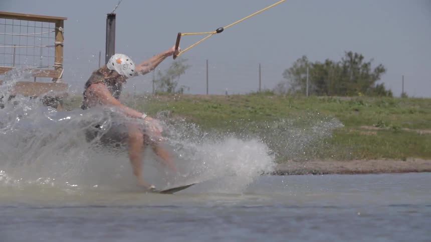 A man jumps onto a lake and wakeboards