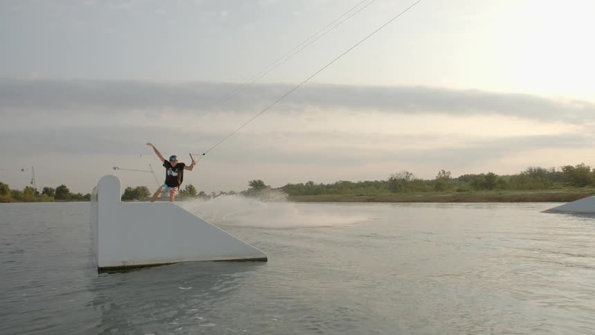 Man being pulled on a water sled makes a jump