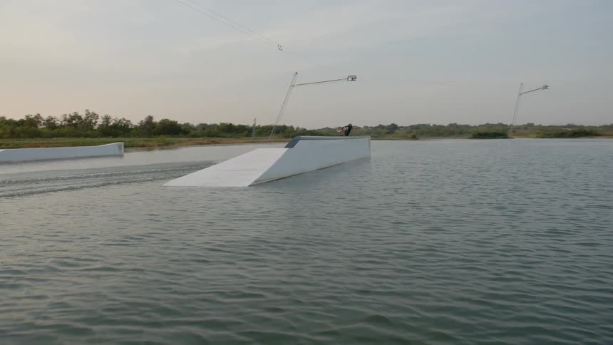 A wakeboarder jumps off of a ramp