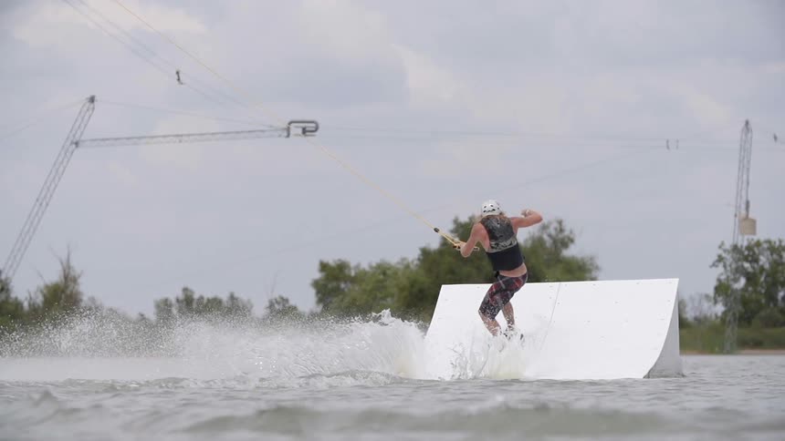 A person does tricks while water skiing