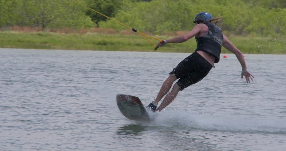 A person does tricks while water skiing