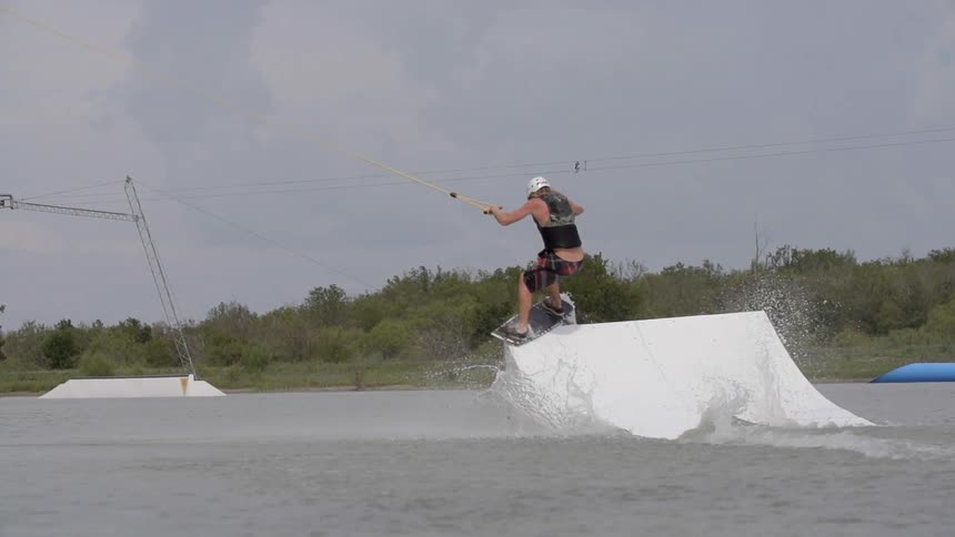 A person does tricks while water skiing