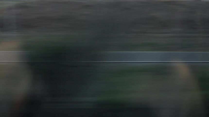 A train travels through a rural area at sunset