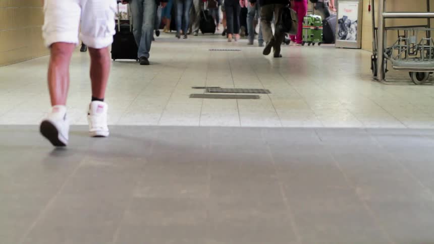 People are walking through an airport concourse
