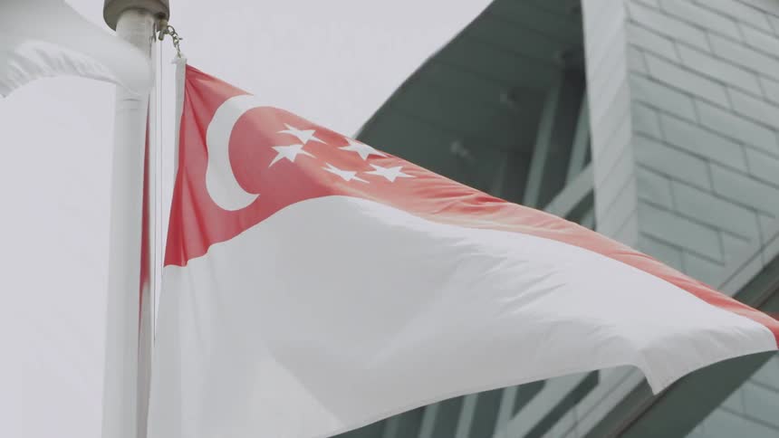 Singapore Flag flying beside a building