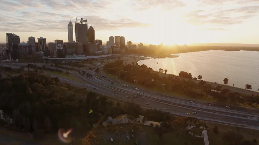 Traffic flows along a freeway in a coastal city at dawn
