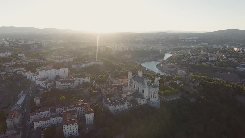The city below is covered with fog at sunrise