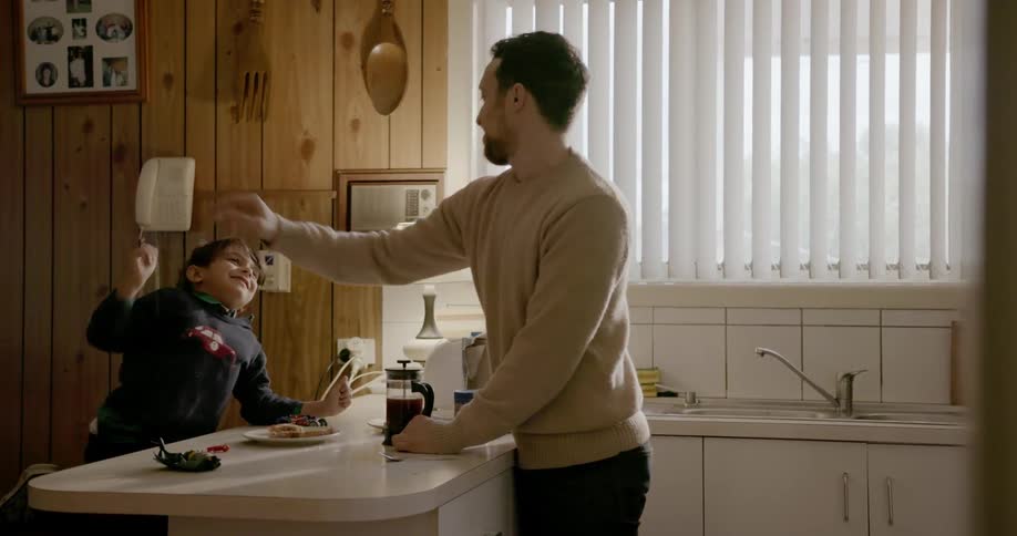A man and a young boy are making coffee together