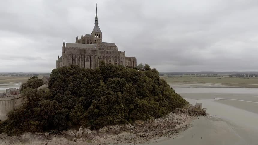 Le mont-saint-michel castle sits under cloudy skies during the day