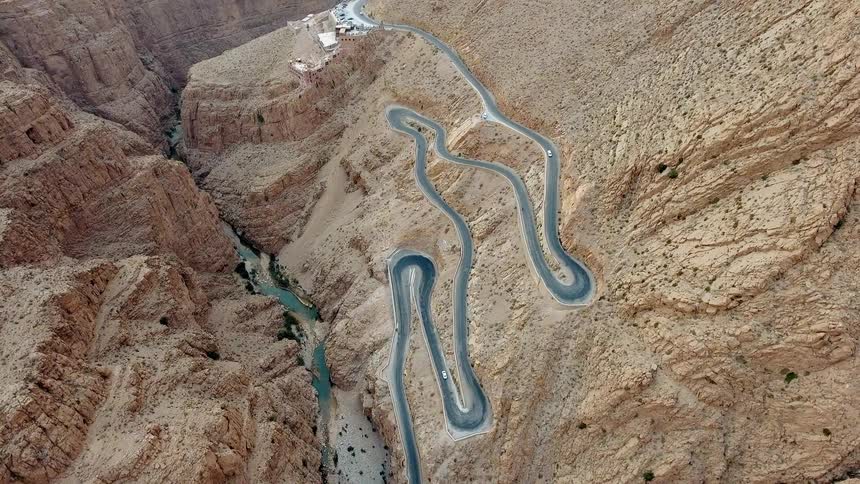 A vehicle travels down a windy canyon road