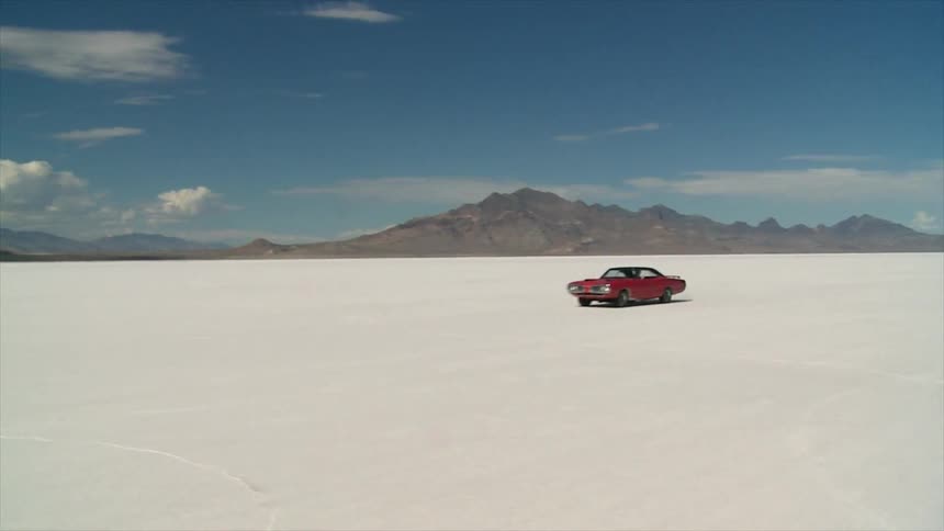 A red car races across the desert