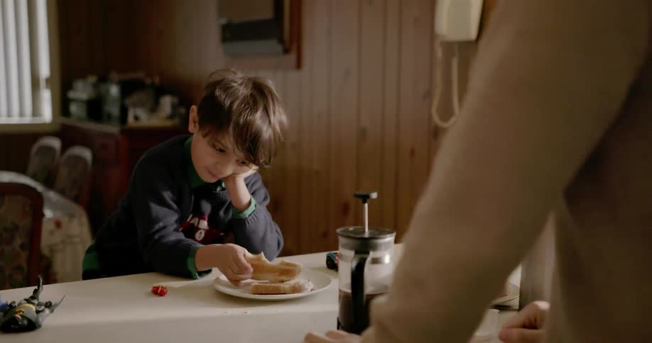 A boy is eating some lunch and talking
