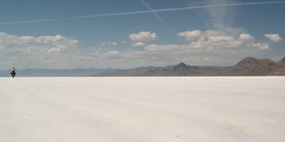 Person riding street motorcycle on salt flats