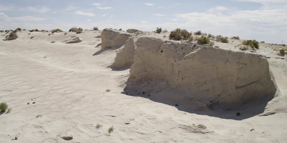 The desert has tall rocks and some small bushes