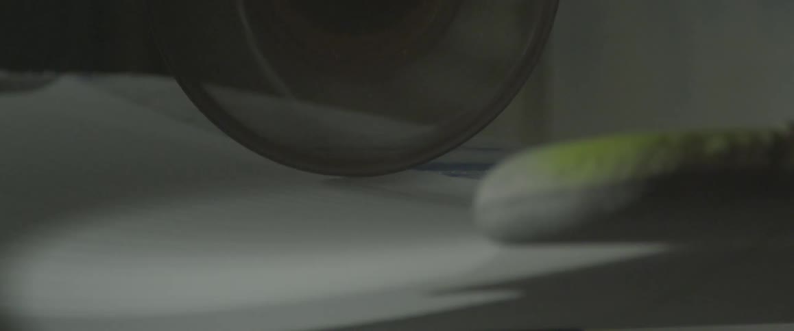 A piece of spinning machinery moves over the surface of an object