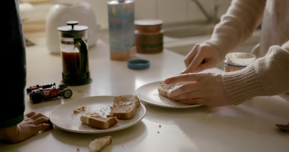 Man and boy eat toast at kitchen counter