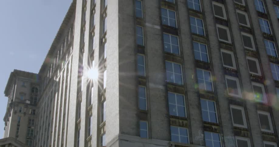 A large building is filmed from the street