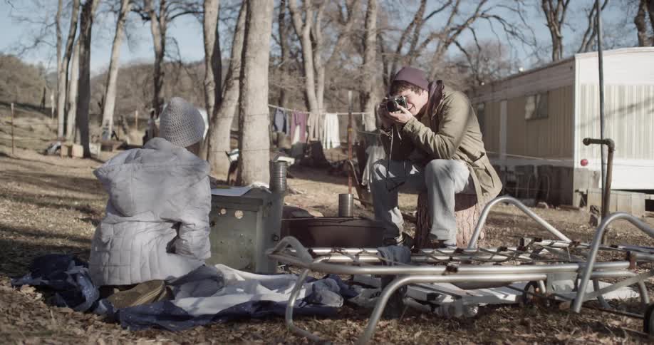 Man takes picture of another person sitting down