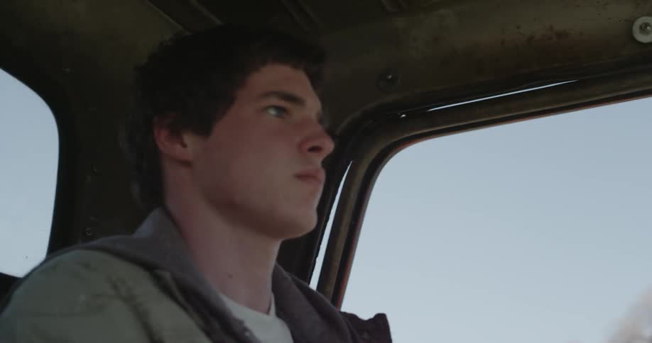 A young man drives a pickup truck