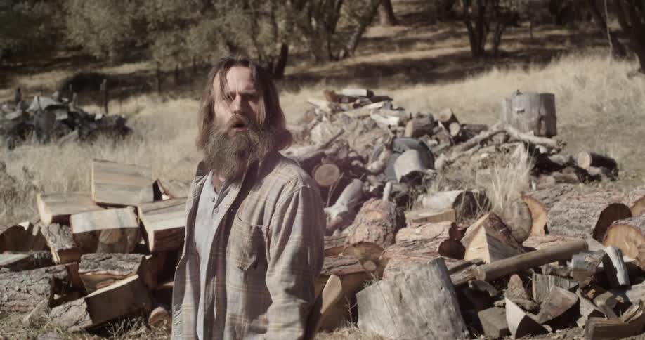 A man stops chopping wood and runs off