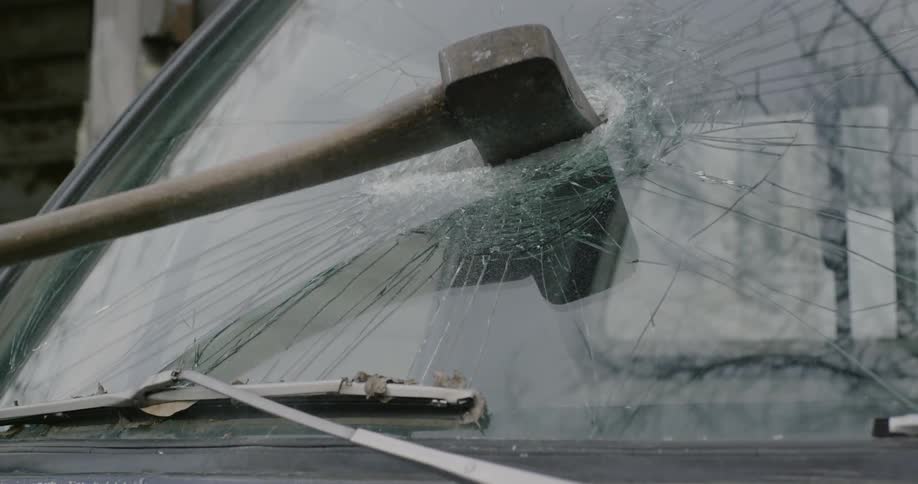 A hatchet is thrown through a windshield