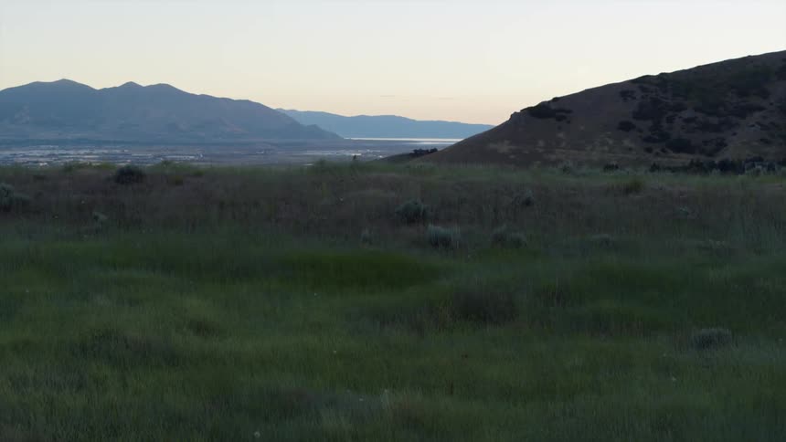 The grassy hill leads to a town ahead