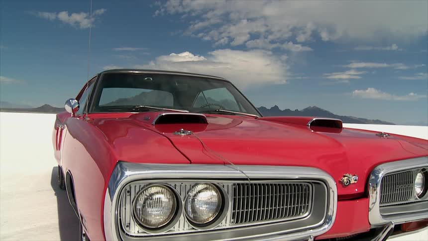 A red sports car is parked in the sand