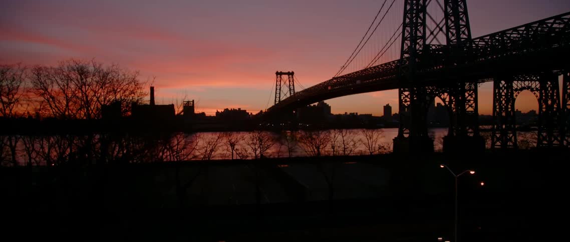 The sun is setting making the sky a nice color behind the bridge