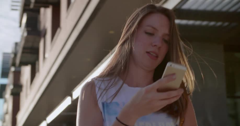 A woman is talking on the phone as she walks down the street