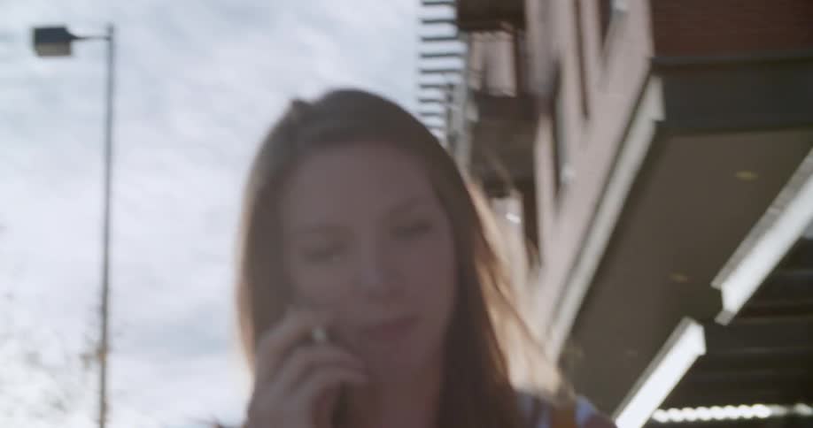 Woman taking on a phone walking near buildings