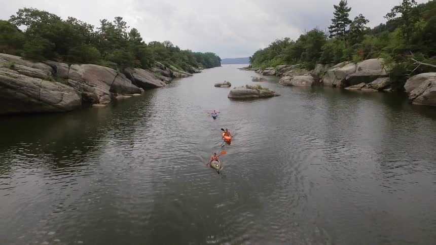 People kayak on a river in the wilderness